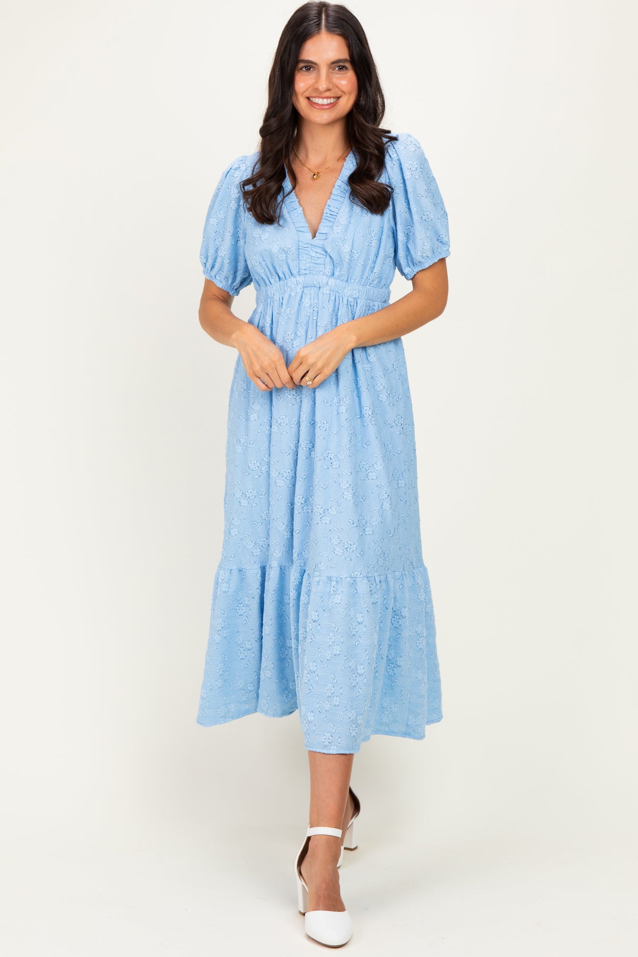 woman wearing a light blue midi dress with puff sleeves and a tiered hem