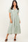 woman wearing a light green puff sleeve midi dress with a v-neck and tiered skirt, standing against a neutral background