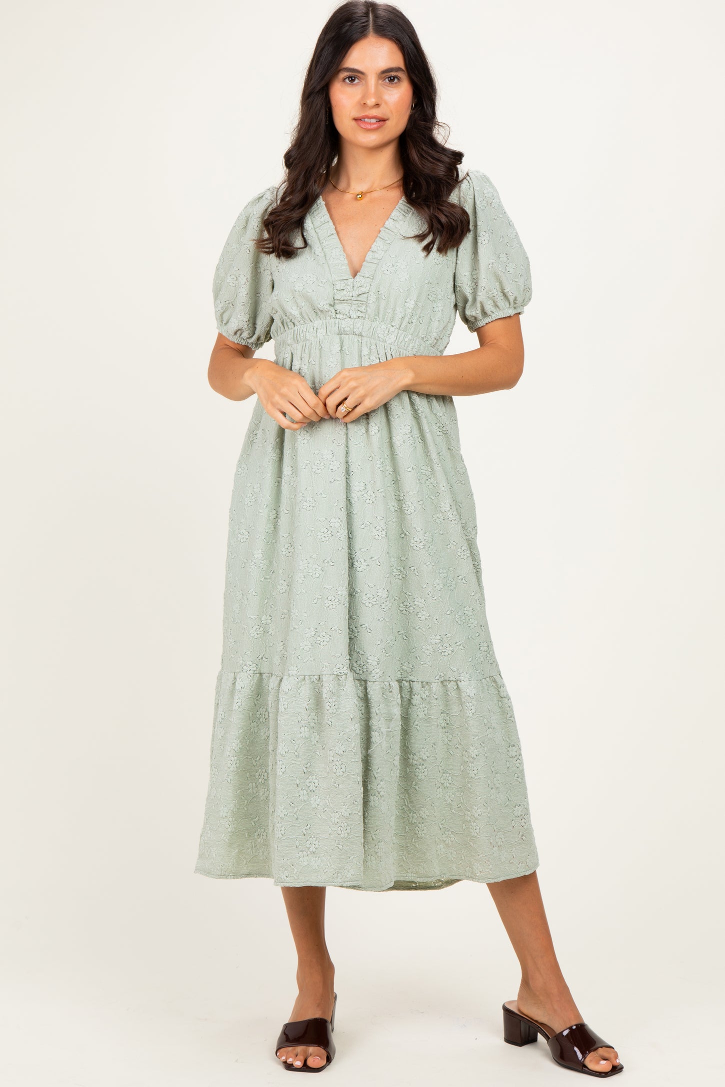 woman wearing a light green midi dress with puff sleeves and a smocked bodice
