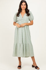 woman wearing a light green midi dress with puff sleeves and a smocked bodice