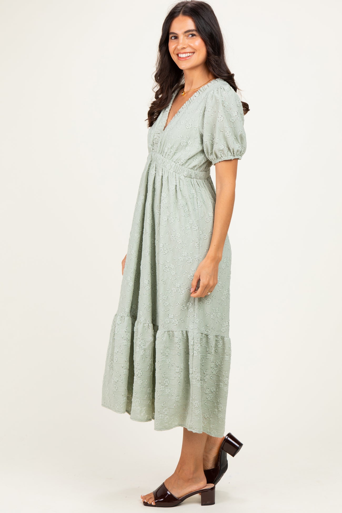 woman wearing a light green puff sleeve midi dress with a tiered skirt and lace detailing