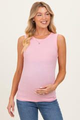 woman wearing a light pink ribbed maternity tank top and holding her baby bump