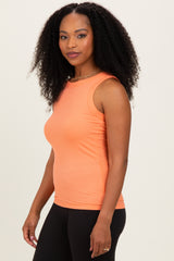 woman wearing a fitted coral ribbed tank top with a round neckline and black leggings