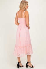 woman wearing a pink lace midi dress with a smocked bodice and ruffled hem, viewed from the back