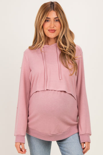 woman wearing a light pink cropped maternity hoodie with a baby bump visible