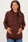 woman wearing a dark brown maternity hoodie, highlighting her baby bump with a relaxed fit and cropped style