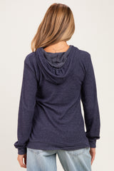 woman wearing a dark navy maternity hoodie with a relaxed fit and a hood, seen from the back
