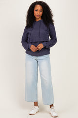 woman wearing a navy blue cropped hoodie with adjustable drawstrings and light blue wide-leg jeans