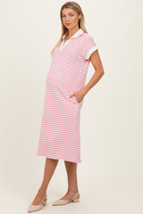 woman wearing a pink and white striped maternity dress with short sleeves and pockets, showcasing her baby bump