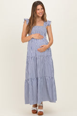 woman wearing a navy and white striped maternity maxi dress with ruffled straps and holding her baby bump