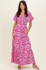 woman wearing a pink floral maxi dress with short flutter sleeves and pockets