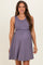 woman wearing a purple ribbed maternity dress with a fitted bodice and flared skirt, showcasing her baby bump