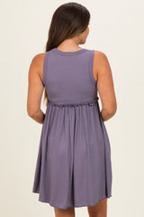 woman wearing a lavender sleeveless maternity dress with a tie waist and a flowy skirt, showing her baby bump from the back