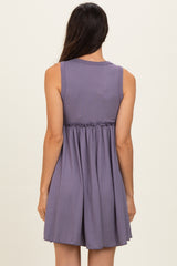 woman wearing a sleeveless purple ribbed dress with an elasticized waist and a flared skirt