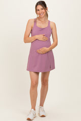 woman wearing a mauve maternity dress with a racerback design and baby bump visible