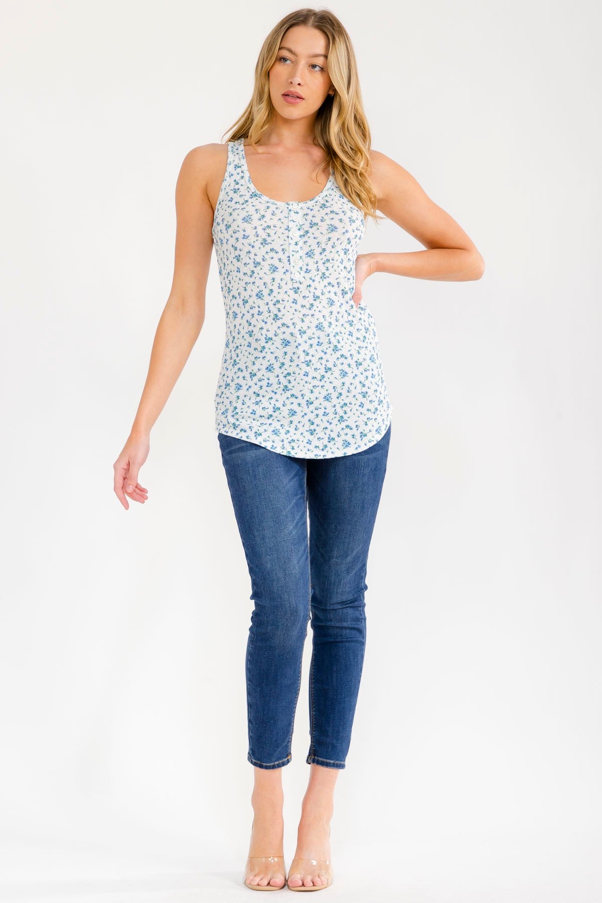 woman wearing a floral print tank top in light blue and white with skinny jeans and beige heels