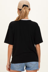 woman wearing a black oversized maternity t-shirt with a white collar and denim shorts, showing her back view