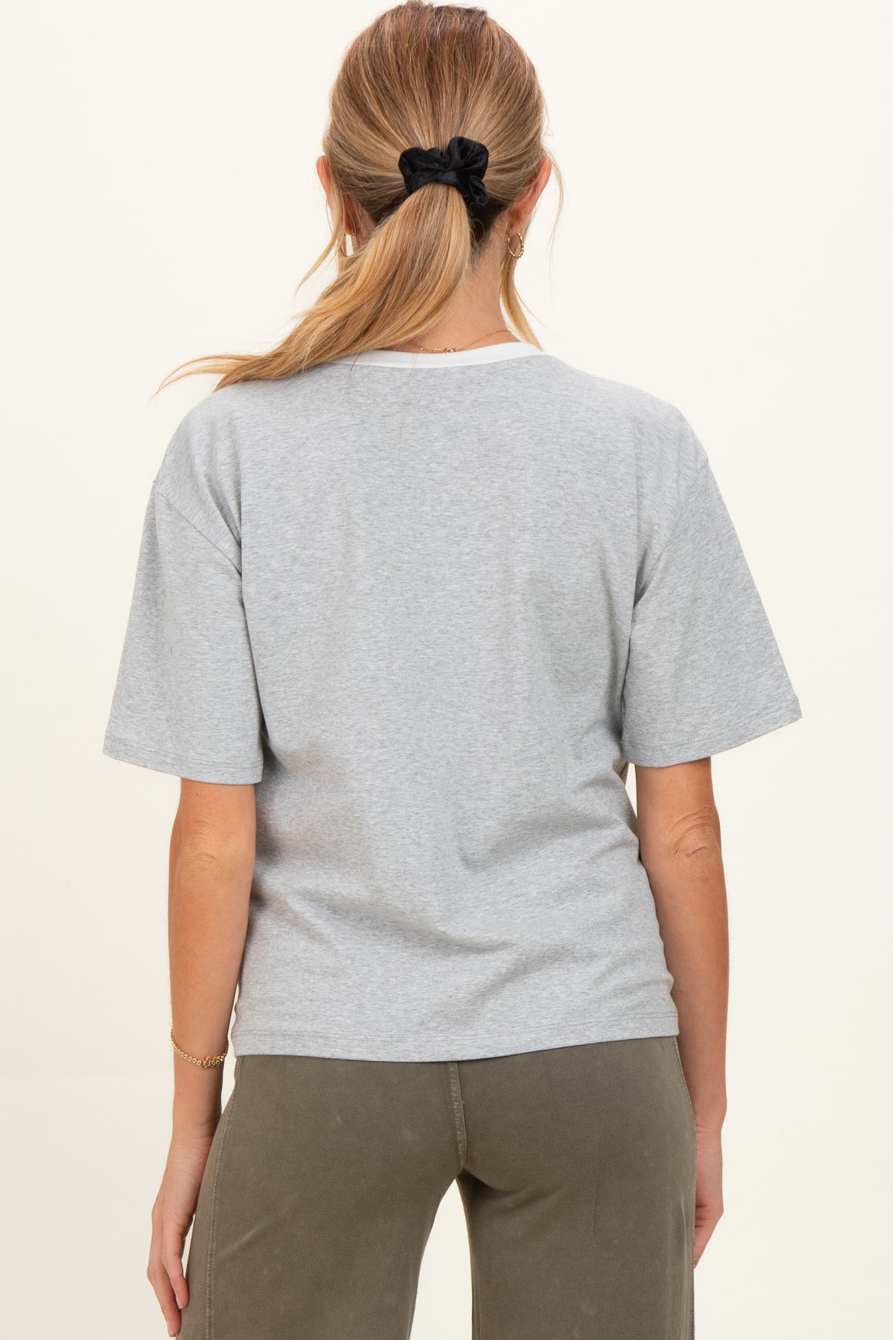 woman wearing a gray maternity t-shirt with short sleeves and a relaxed fit, viewed from the back