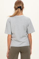 woman wearing a gray maternity t-shirt with short sleeves and a relaxed fit, viewed from the back