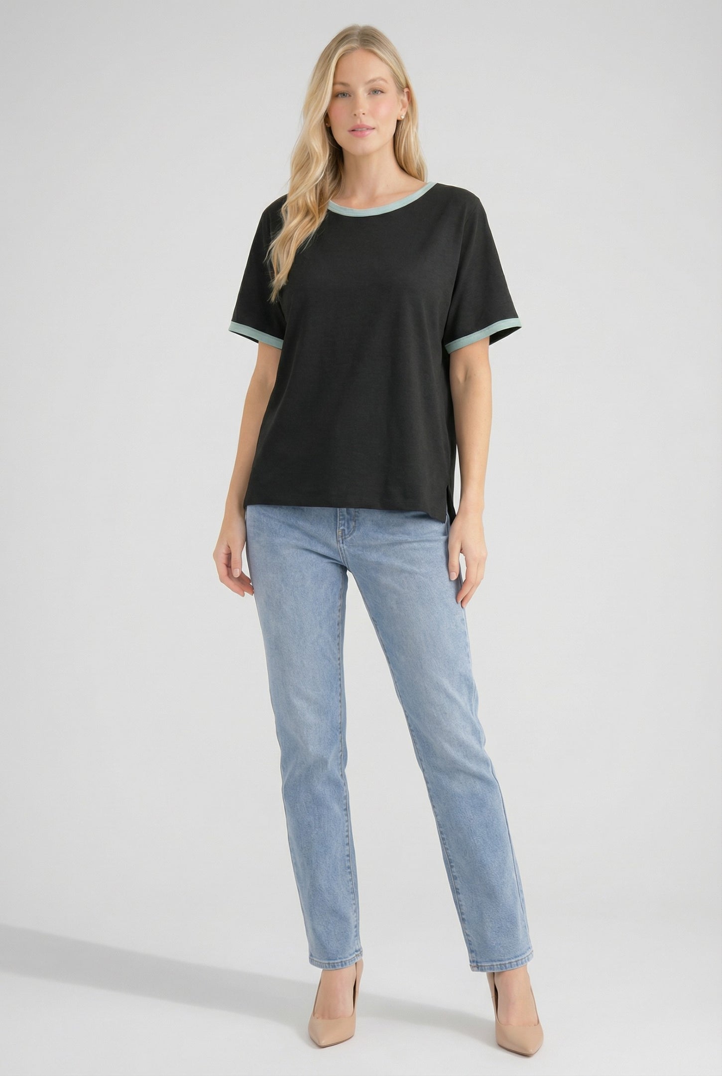 woman wearing a black short sleeve t-shirt with a teal trim and light blue jeans