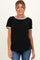 woman wearing a black maternity top with light blue trim and short sleeves, smiling and standing casually