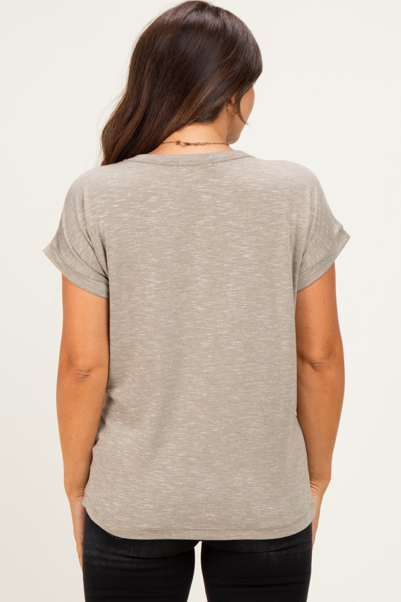 woman wearing a light taupe maternity top with rolled sleeves, shown from the back