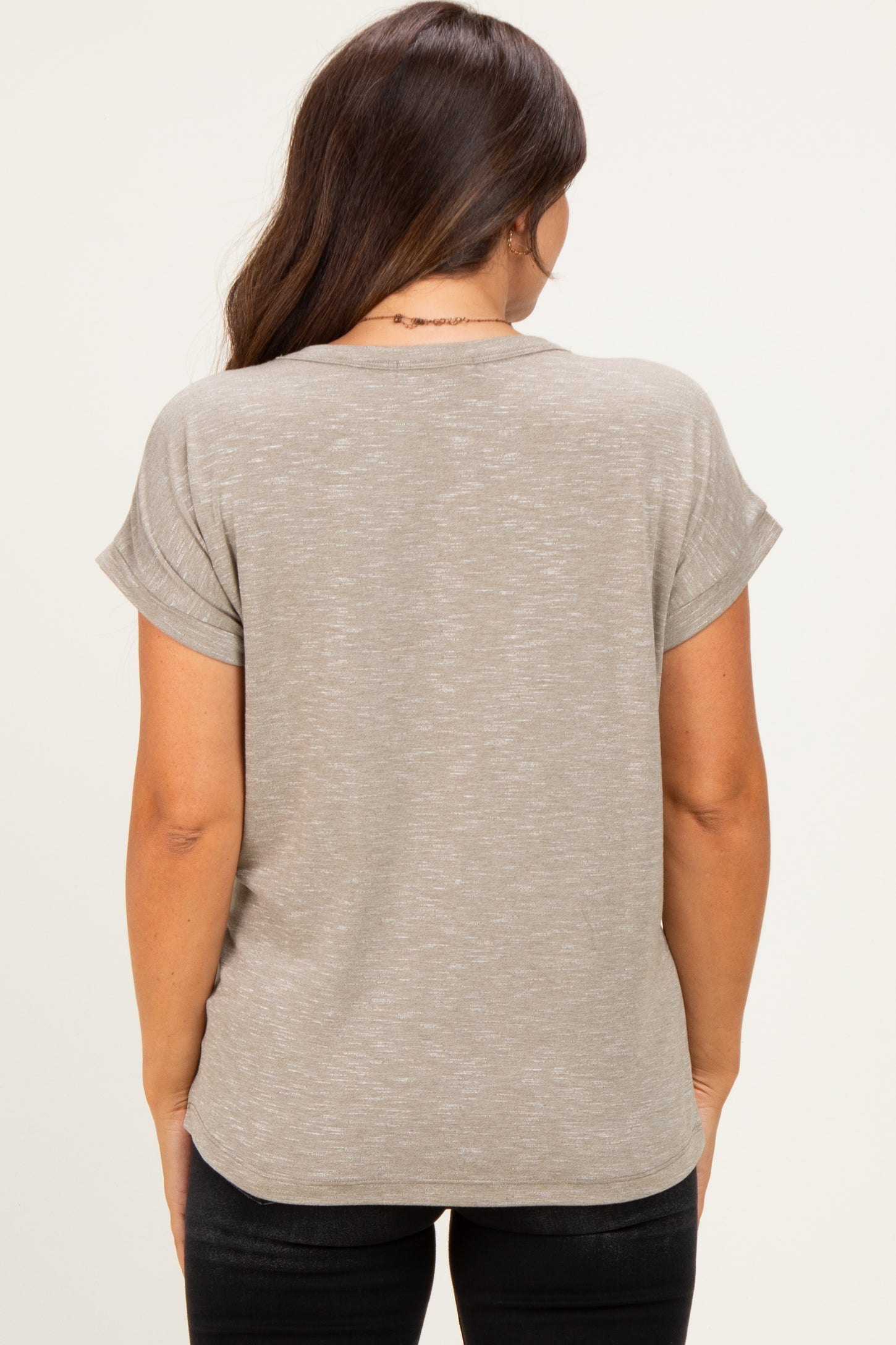 woman wearing a light taupe maternity top with rolled sleeves, shown from the back