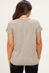 woman wearing a light taupe maternity top with rolled sleeves, shown from the back