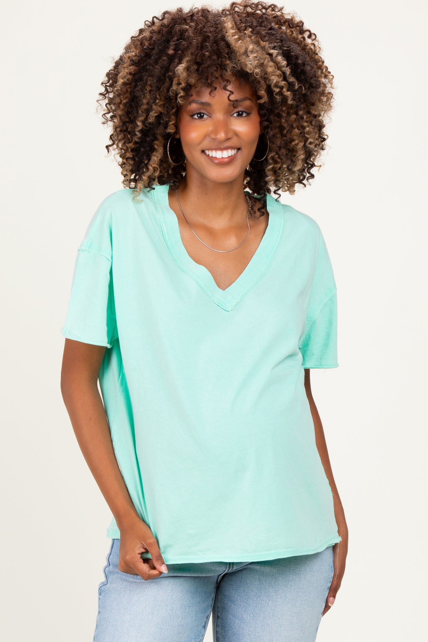 woman wearing a mint green maternity v-neck t-shirt with a relaxed fit and short sleeves