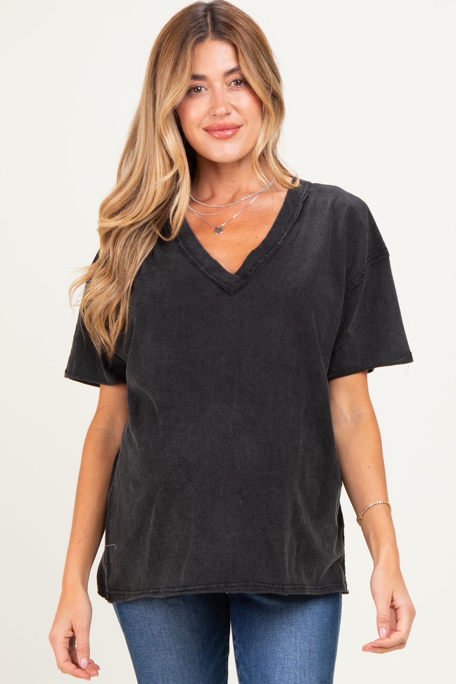 woman wearing a black oversized v-neck maternity t-shirt with short sleeves and a loose fit