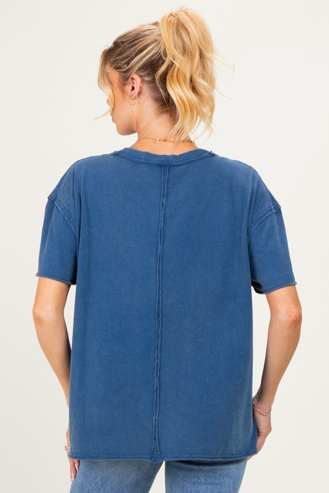 woman wearing a relaxed fit blue maternity top with short sleeves and a seam detail on the back