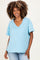 woman wearing a light blue v-neck maternity top with short sleeves and a relaxed fit