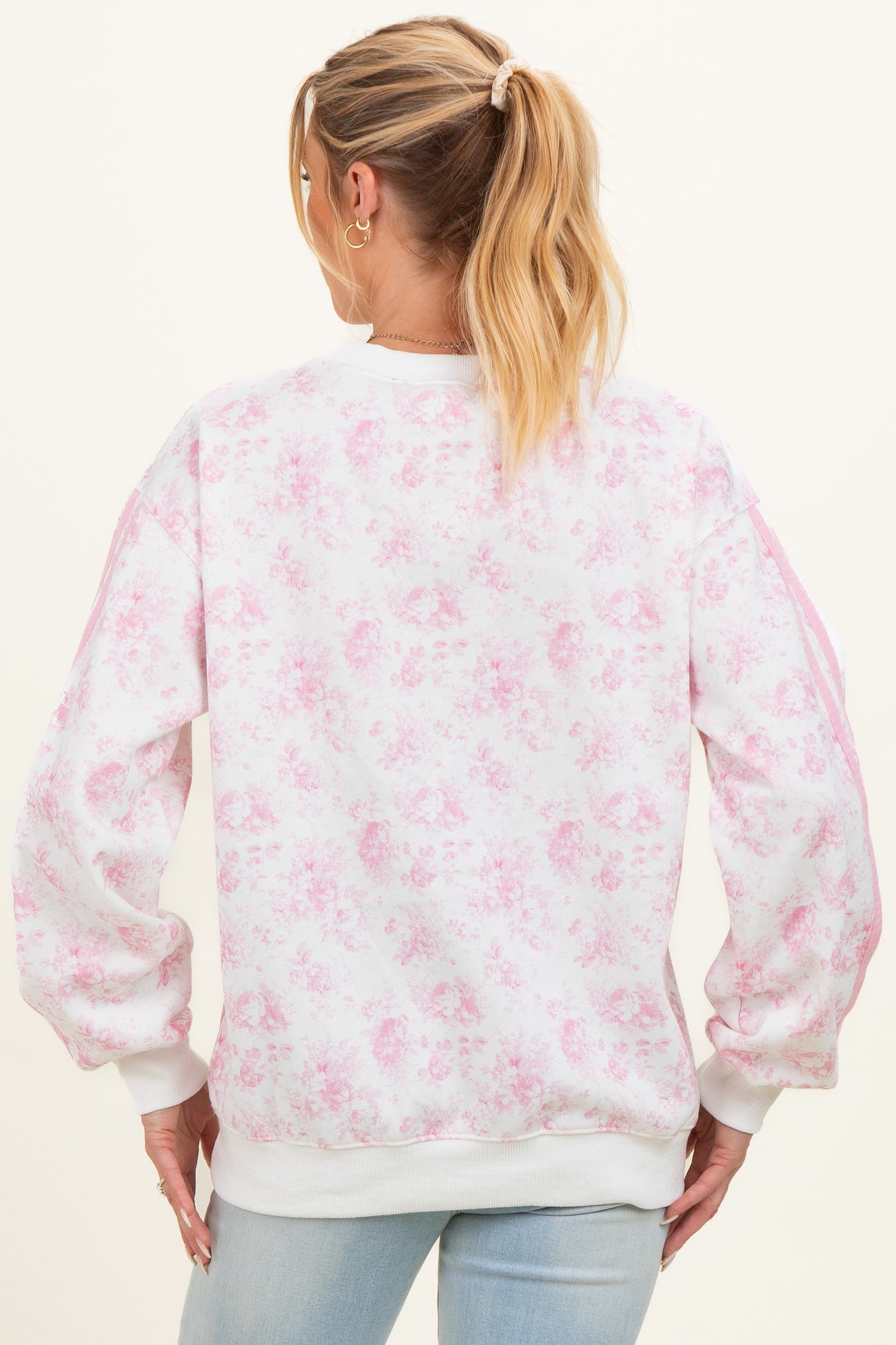 woman wearing a floral print maternity sweatshirt in light pink with puffed sleeves and a relaxed fit