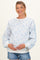 woman wearing a pastel blue floral print maternity sweatshirt with long sleeves and holding her baby bump