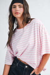 woman wearing a pink and white striped oversized t-shirt with short sleeves and a relaxed fit