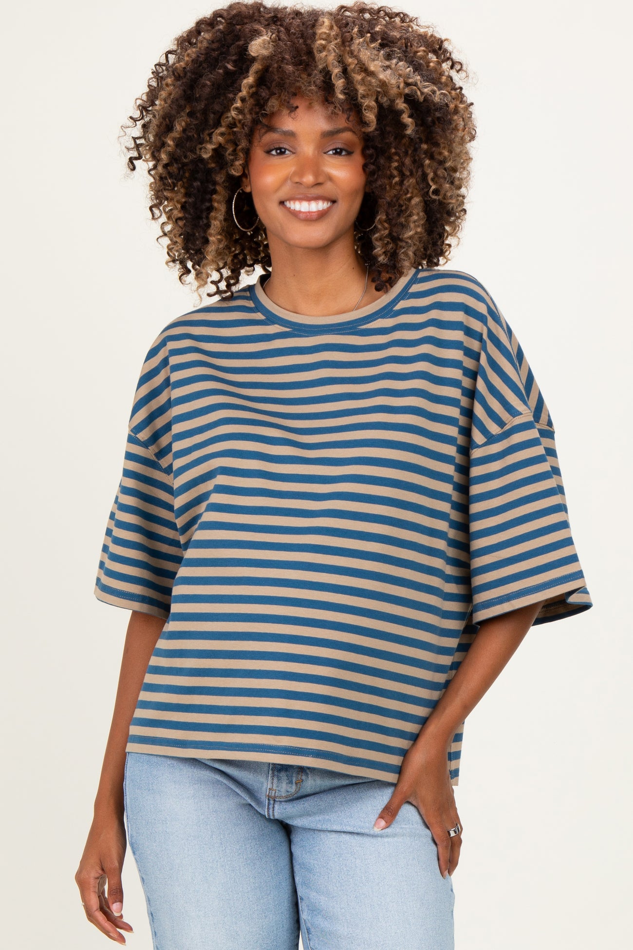 woman wearing a brown and blue striped oversized maternity top with wide sleeves