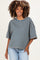 woman wearing a brown and blue striped oversized maternity top with wide sleeves