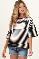 woman wearing a black and white striped maternity top with short sleeves and a relaxed fit, paired with denim shorts