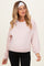 woman wearing a light pink maternity sweatshirt with long sleeves and a relaxed fit, showcasing a visible baby bump