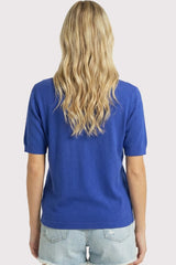 woman wearing a royal blue short sleeve sweater with a relaxed fit and styled with denim shorts