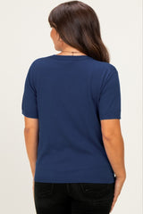 woman wearing a navy blue short sleeve maternity top, shown from the back
