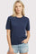 woman wearing a navy blue short sleeve sweater and light denim shorts