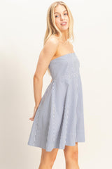 woman wearing a navy and white striped strapless sundress with a flared skirt