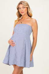 woman wearing a striped strapless maternity dress and holding her baby bump