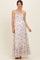 woman wearing a floral maternity maxi dress with halter straps and a ruffled hem, showcasing her baby bump