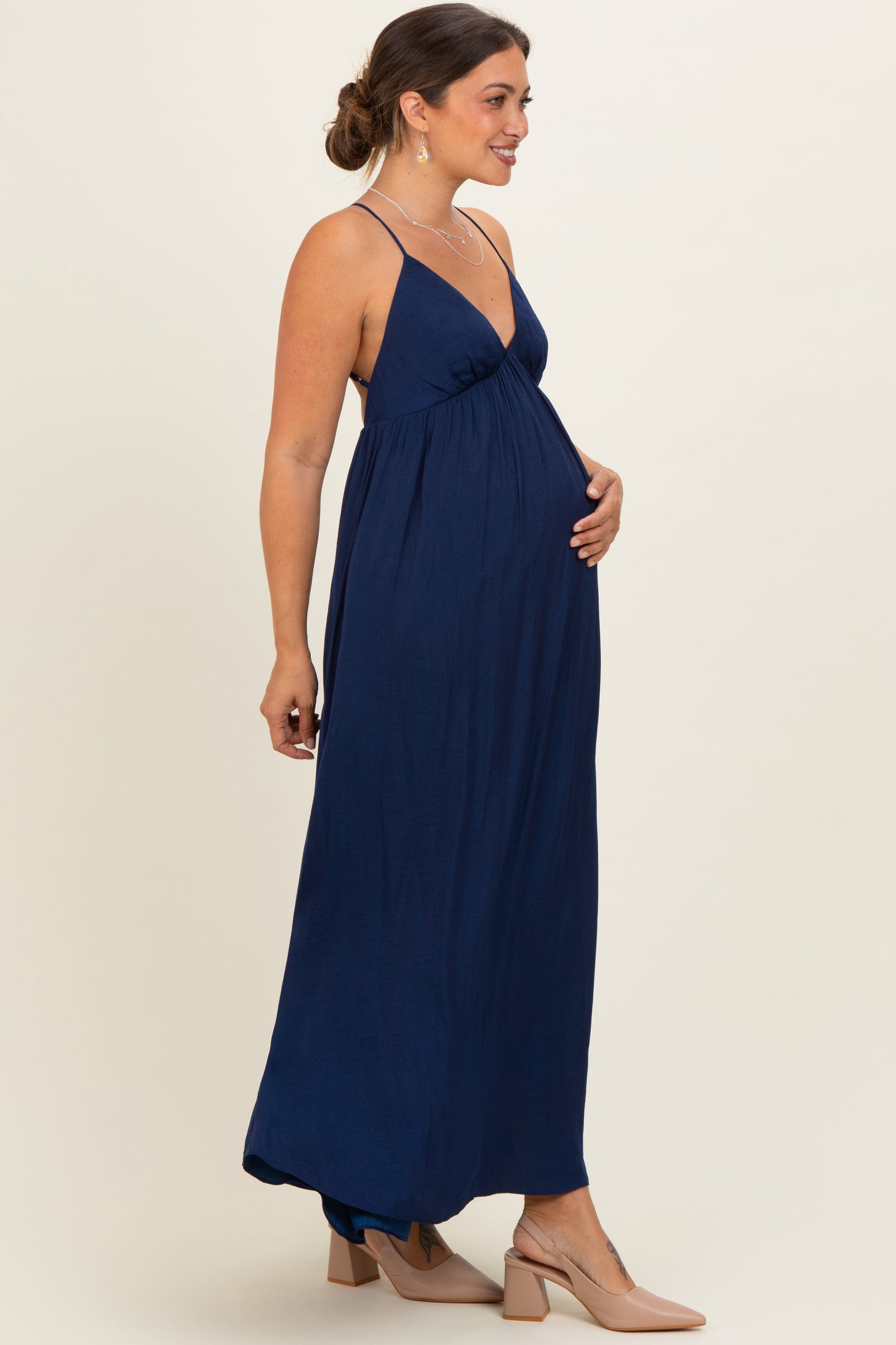 woman wearing a navy blue sleeveless maternity maxi dress, showing her baby bump with a relaxed fit and flowy design