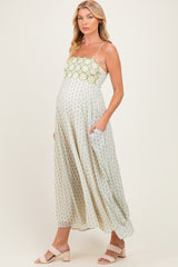 woman wearing a midi maternity dress with a floral pattern and pockets, showcasing her baby bump