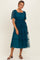 woman wearing a teal smocked midi dress with sheer puff sleeves and ruffled tulle layers