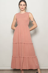 woman wearing a dusty rose sleeveless maxi dress with ruffle details and tiered skirt
