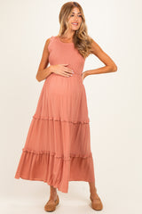 woman wearing a dusty rose maternity maxi dress with ruffle details and a visible baby bump